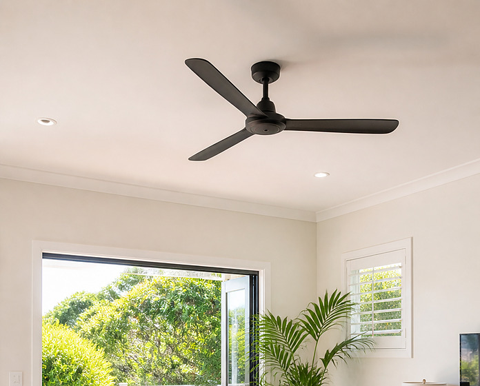 Black three blade ceiling fan on a white ceiling in a bright coastal living room